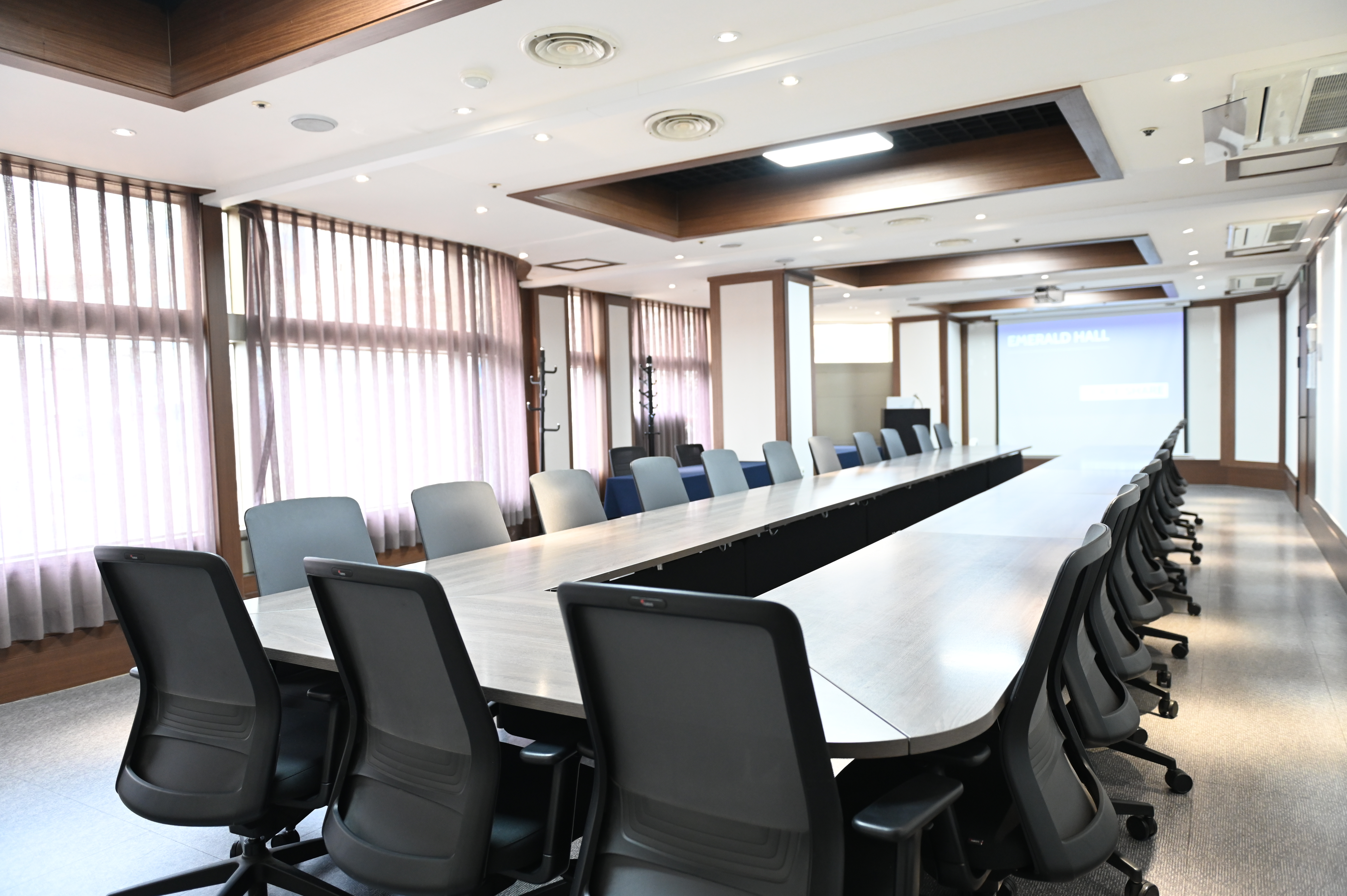 스페이스쉐어 서울역센터 에메랄드홀 측면, 넓은 좌석 배치 및 퍼시스 테이블과 고급 의자