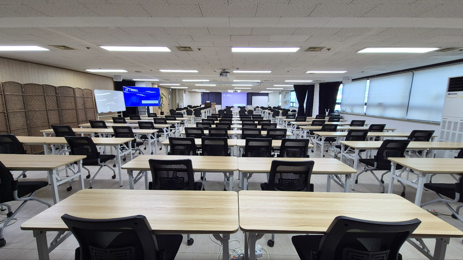 스페이스쉐어 지밸리센터 IT홀 정면, 대형 스크린과 음향 시설을 갖춘 강의장